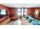Open living room with wood-look floors, large windows, a TV, and comfortable seating at 7415 San Moritz Dr, Port Richey, FL 34668