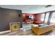 Spacious living room with wood-look flooring, neutral furniture, a large TV and colorful art at 7415 San Moritz Dr, Port Richey, FL 34668
