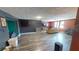 Spacious living room with wood-look floors, large windows, a TV, and comfortable seating at 7415 San Moritz Dr, Port Richey, FL 34668