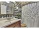 Quaint bathroom featuring whimsical wallpaper, pedestal sink, and shower with white curtain at 7924 Singing Court Pl, Tampa, FL 33615