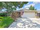 Charming home with a stone facade, large garage, and a well-manicured lawn at 7924 Singing Court Pl, Tampa, FL 33615
