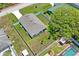 Aerial view of a house with a fenced yard, surrounded by lush trees at 8508 Bay Dr, Spring Hill, FL 34606