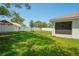 Sprawling backyard with green grass, privacy fence, and screened lanai at 8508 Bay Dr, Spring Hill, FL 34606