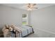 Comfortable bedroom with plush carpet, a ceiling fan, and a bright window, offering a cozy and inviting space at 8508 Bay Dr, Spring Hill, FL 34606