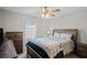 Cozy bedroom showcases wood furniture, a ceiling fan, and natural light through the window with blinds at 8508 Bay Dr, Spring Hill, FL 34606