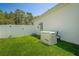 Features a Generac generator, surrounded by green grass and a white fence at 8508 Bay Dr, Spring Hill, FL 34606