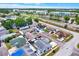 An aerial view showcases a neighborhood with mature trees, modern offices, and a serene pond at 8708 Albion Ct, Tampa, FL 33634