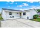 Charming single-story home featuring a covered front porch and a well-maintained concrete driveway and white facade at 8708 Albion Ct, Tampa, FL 33634
