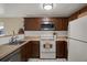 Functional kitchen featuring wooden cabinets, stainless steel microwave, white appliances, and ample counter space at 8708 Albion Ct, Tampa, FL 33634