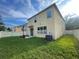 The well-maintained backyard includes green grass, AC unit, partial fence, and view of neighboring houses at 9126 Lantern Oak Way, Land O Lakes, FL 34638