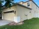 Side view of an attached two car garage with exterior lighting, and manicured landscaping in front of a two-story home at 9126 Lantern Oak Way, Land O Lakes, FL 34638