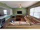 A spacious living room featuring an accent wall, a large sectional couch, tile flooring, and plenty of natural light at 9126 Lantern Oak Way, Land O Lakes, FL 34638