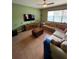Relaxing living room featuring a large sectional couch, an accent wall, tile flooring, and a ceiling fan at 9126 Lantern Oak Way, Land O Lakes, FL 34638