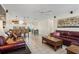 Spacious open-concept living room with tile floors, leather sofas, and seamless flow to kitchen and dining at 9226 41St N St, Pinellas Park, FL 33782