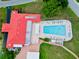 Aerial view of the community pool with lounge chairs, a clubhouse and a red tile roof at 9226 41St N St, Pinellas Park, FL 33782