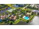 Aerial view of a community with a pool, tennis courts, and a pond, surrounded by trees and landscaping at 9416 Lake Chase Island Way # 9416, Tampa, FL 33626