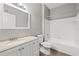 Bright bathroom with modern vanity, framed mirror, and a white tiled shower/tub combo at 9416 Lake Chase Island Way # 9416, Tampa, FL 33626