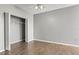 Bedroom featuring wood-look flooring, neutral walls, ceiling fan, and an open closet with double doors at 9416 Lake Chase Island Way # 9416, Tampa, FL 33626