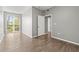 Spacious bedroom with wood-look flooring, natural light, and a doorway to another room at 9416 Lake Chase Island Way # 9416, Tampa, FL 33626