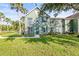 Well-manicured exterior of home with lush green lawn, sidewalk, and mature trees providing shade at 9416 Lake Chase Island Way # 9416, Tampa, FL 33626