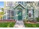 Inviting front entrance with green door, lush landscaping, and well-maintained walkway leading up to the home at 9416 Lake Chase Island Way # 9416, Tampa, FL 33626
