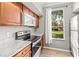 Bright kitchen featuring stainless steel appliances, granite countertops, and view to landscaped outdoors at 9416 Lake Chase Island Way # 9416, Tampa, FL 33626