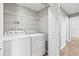 Laundry room with white washer and dryer, wire shelving, and access to other areas of the house at 9416 Lake Chase Island Way # 9416, Tampa, FL 33626