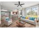 Open-concept living room featuring modern furniture, a ceiling fan and a bar overlooking the kitchen at 9416 Lake Chase Island Way # 9416, Tampa, FL 33626