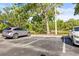 Parking lot with parked cars, trees, and a view of a pond with lush green landscaping at 9416 Lake Chase Island Way # 9416, Tampa, FL 33626