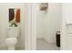 This half bathroom features a toilet, storage, and simple decor at 9417 Raised Tulip Ln, Land O Lakes, FL 34637
