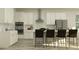 Modern kitchen with white cabinets, stainless steel appliances, and bar stool seating at 9486 Gladsome Dr, Land O Lakes, FL 34637