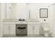 Well-lit bathroom offers double sinks with white cabinets and granite countertops with decor at 10808 Keato Beach Ct, Tampa, FL 33647
