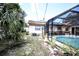 A backyard view showcasing a screened-in pool area, with solar panels on the house at 11411 N 19Th St, Tampa, FL 33612
