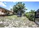 Spacious backyard featuring an open green space, mature tree, a trampoline, and partial view of the home's exterior at 11411 N 19Th St, Tampa, FL 33612
