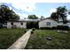 Charming single-story home featuring solar panels, a well-maintained lawn, and a welcoming walkway at 11411 N 19Th St, Tampa, FL 33612