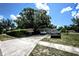 Exterior view of a single-story home with a mature tree, vehicles in the driveway, and a well-maintained front yard at 11411 N 19Th St, Tampa, FL 33612