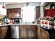 Traditional kitchen featuring dark wood cabinets, granite countertops, stainless steel appliances, and mosaic backsplash at 11411 N 19Th St, Tampa, FL 33612