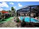 Exterior shot showcasing the caged pool, patio set, and umbrella for a relaxing outdoor experience at 11411 N 19Th St, Tampa, FL 33612