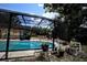 A screened pool area features clear blue water, an outdoor patio, and comfortable lounge chairs at 11411 N 19Th St, Tampa, FL 33612
