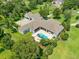 Aerial view of the house highlighting the pool, patio area, landscaping and expansive lawn at 11441 Hammock Oaks Ct, Lithia, FL 33547