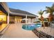 Inviting backyard pool with waterfall feature, lush landscaping, and comfortable lounging area at 11441 Hammock Oaks Ct, Lithia, FL 33547