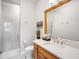 Bright bathroom featuring a glass shower, wood vanity, and contemporary fixtures at 11441 Hammock Oaks Ct, Lithia, FL 33547