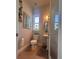 Well-lit bathroom featuring a pedestal sink, toilet, window, and framed picture at 11441 Hammock Oaks Ct, Lithia, FL 33547