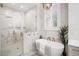 Luxurious bathroom features a glass enclosed shower, soaking tub, and modern fixtures at 11441 Hammock Oaks Ct, Lithia, FL 33547