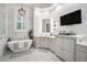 Elegant bathroom featuring a soaking tub, chandelier, vanity, and a TV for relaxation at 11441 Hammock Oaks Ct, Lithia, FL 33547