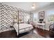 Modern bedroom featuring a four-poster bed, stylish wallpaper, and a cozy workspace at 11441 Hammock Oaks Ct, Lithia, FL 33547