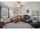Cozy bedroom with a ceiling fan, wooden floors, and a comfortable lounge area at 11441 Hammock Oaks Ct, Lithia, FL 33547