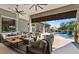 Spacious covered patio featuring comfortable seating, ceiling fans, and a view of the pool at 11441 Hammock Oaks Ct, Lithia, FL 33547