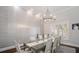 Formal dining room with stylish chandelier, textured wallpaper, and seating for six at 11441 Hammock Oaks Ct, Lithia, FL 33547