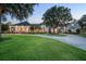 Stunning two-story home featuring a welcoming front porch, lush landscaping, and a circular driveway at 11441 Hammock Oaks Ct, Lithia, FL 33547